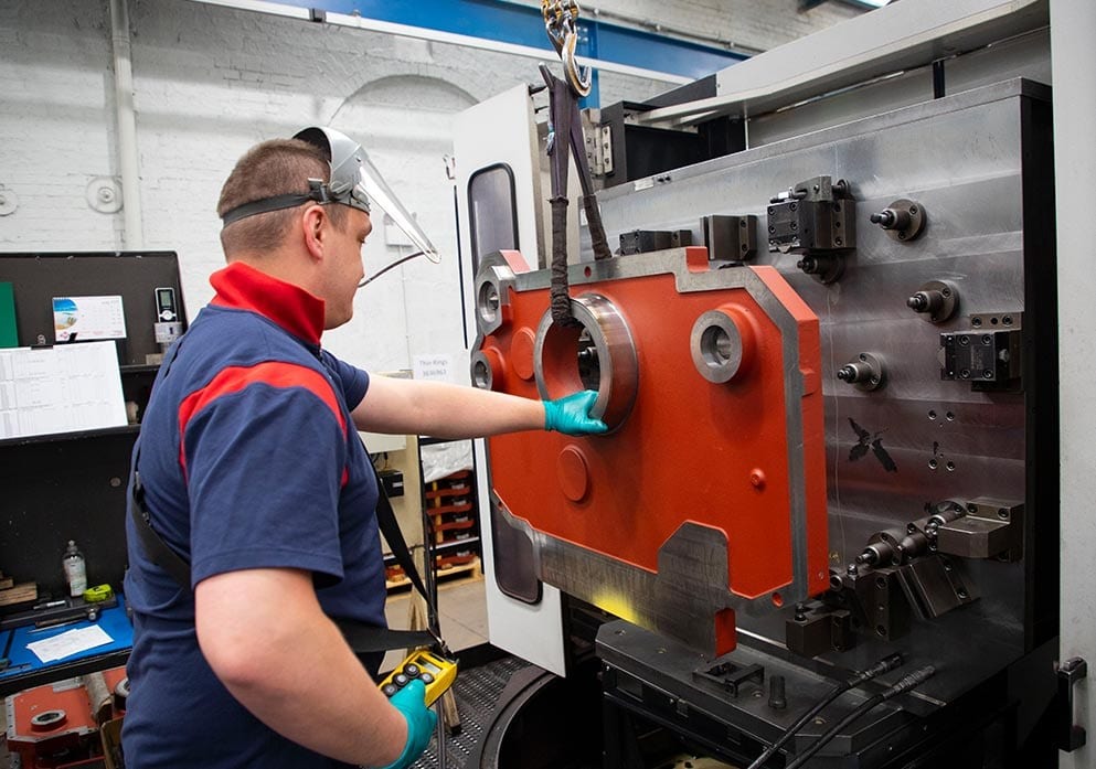 A machinist loading a large casting onto a fixture